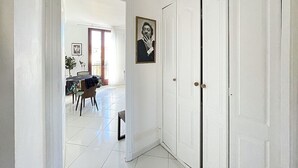A hallway with a white door, a dining area with a table and chairs, and a framed picture on the wall. - Viva Riviera Apartment with balcony near the sea (Cannes)