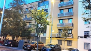 A multi-story building with balconies, parked cars, and a street lamp. - Room-cozy Guest Room in Modern Madrid Fl (Madrid)