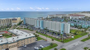 Un hotel con diversi edifici, un parcheggio e vista sull'oceano.