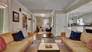 A spacious living room with two sofas, a coffee table, and a kitchen area visible in the background. - Central Royal Oak 3BR Home Near Woodward, Birmingham & Detroit Zoo (Royal Oak)