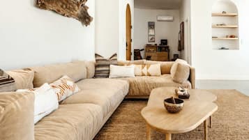 Un salon avec un canapé beige, une table basse en bois et une décoration murale de style rustique.