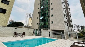 A high-rise building with a swimming pool and outdoor seating area. - LK Barro Preto 5 (Belo Horizonte)