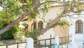 Ein Gebäude mit Bogenfenstern und ein Baum davor.