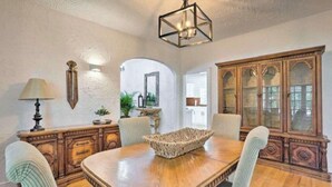 A dining area with a wooden table, chairs, a chandelier, and a cabinet. - 5 Bedroom Mini Resort with Pool! (Boynton Beach)