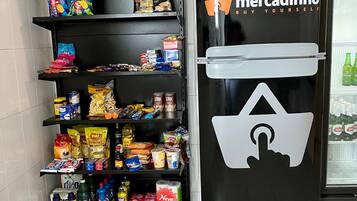 Een bedieningsautomaat met diverse snacks en drankjes, zoals chips, frisdranken en verpakte producten.