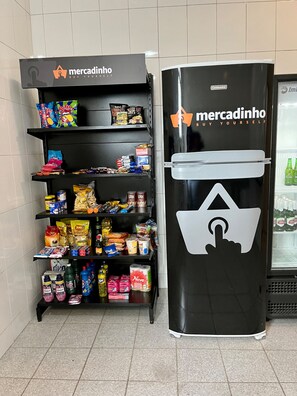 Un quiosco autoservicio con una variedad de aperitivos y bebidas, como papas fritas, refrescos y productos envasados.
