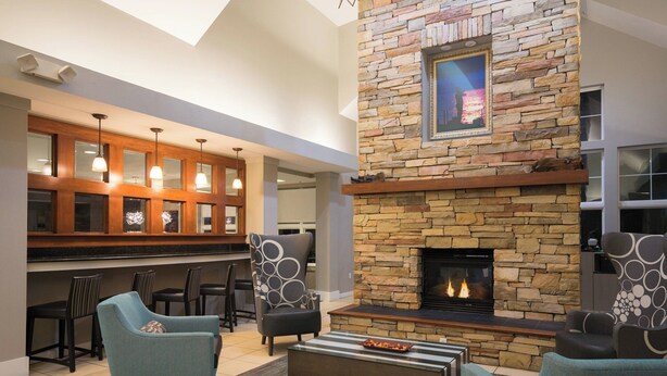 A modern interior with a stone fireplace, dining area, and seating.
