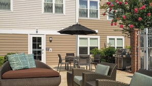 A patio with wicker furniture, a grill, and a covered dining area. - Studio King | Marriott Salisbury | Salisbury U, UMES, Shore Base | 2 Units (Salisbury)