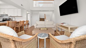 A modern interior with a dining area, sofa, and TV. - Three Bedroom Bay View Townhome in Fenwick Island (Fenwick Island)