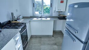 A kitchen with a stove, oven, sink, and refrigerator. - Dpto muy buena ubicacion en Salta, Capital (Salta)