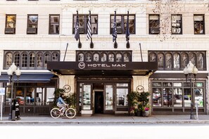 A hotel entrance with a sign reading 'HOTEL MAX,' a bicycle parked outside, and a street lamp on the sidewalk. - Hotel Max | Queen | Art-Filled Lobby, Gallery Halls, Seattle Creative Soul (Seattle)