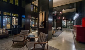 A modern lobby with leather chairs, a guitar display, and a red reception desk. - Pop Queen | Hotel Max | Sub Pop Rooms, Grunge-Era Tribute, Downtown Seattle (Seattle)