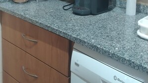 A kitchen with wooden cabinets, a microwave, a coffee maker, and a dishwasher. - Ti Zaquiel Farm (Porto de Mós)