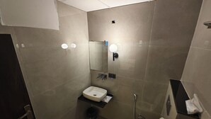 Un baño pequeño con inodoro, lavamanos y espejo.