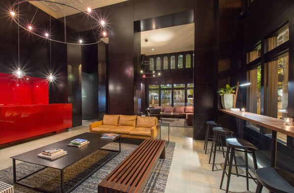 A modern interior with a red seating area, a wooden bench, and a bar counter.