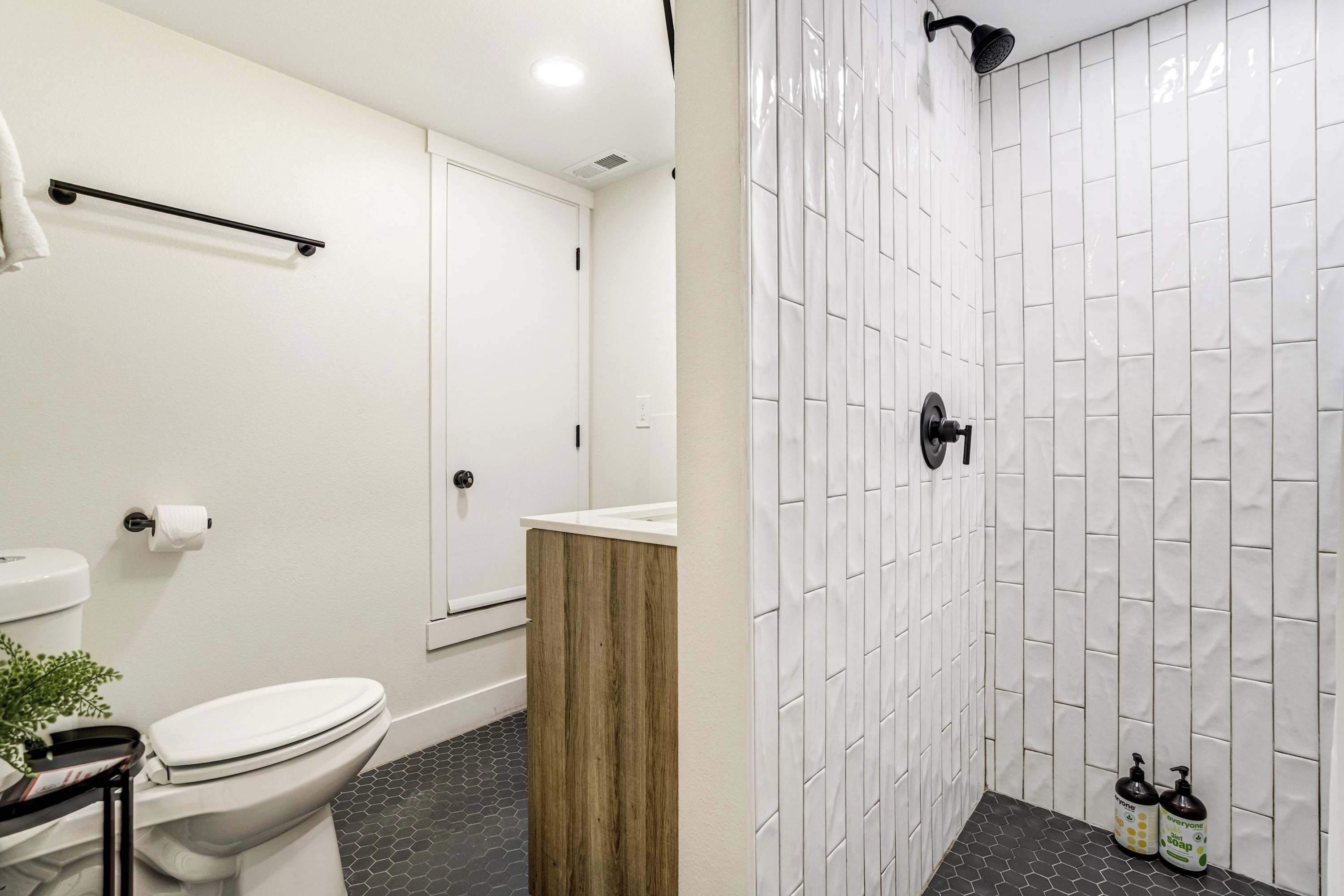 Une salle de bain équipée d’un WC, d’un lavabo, d’une douche et d’un porte-serviettes.