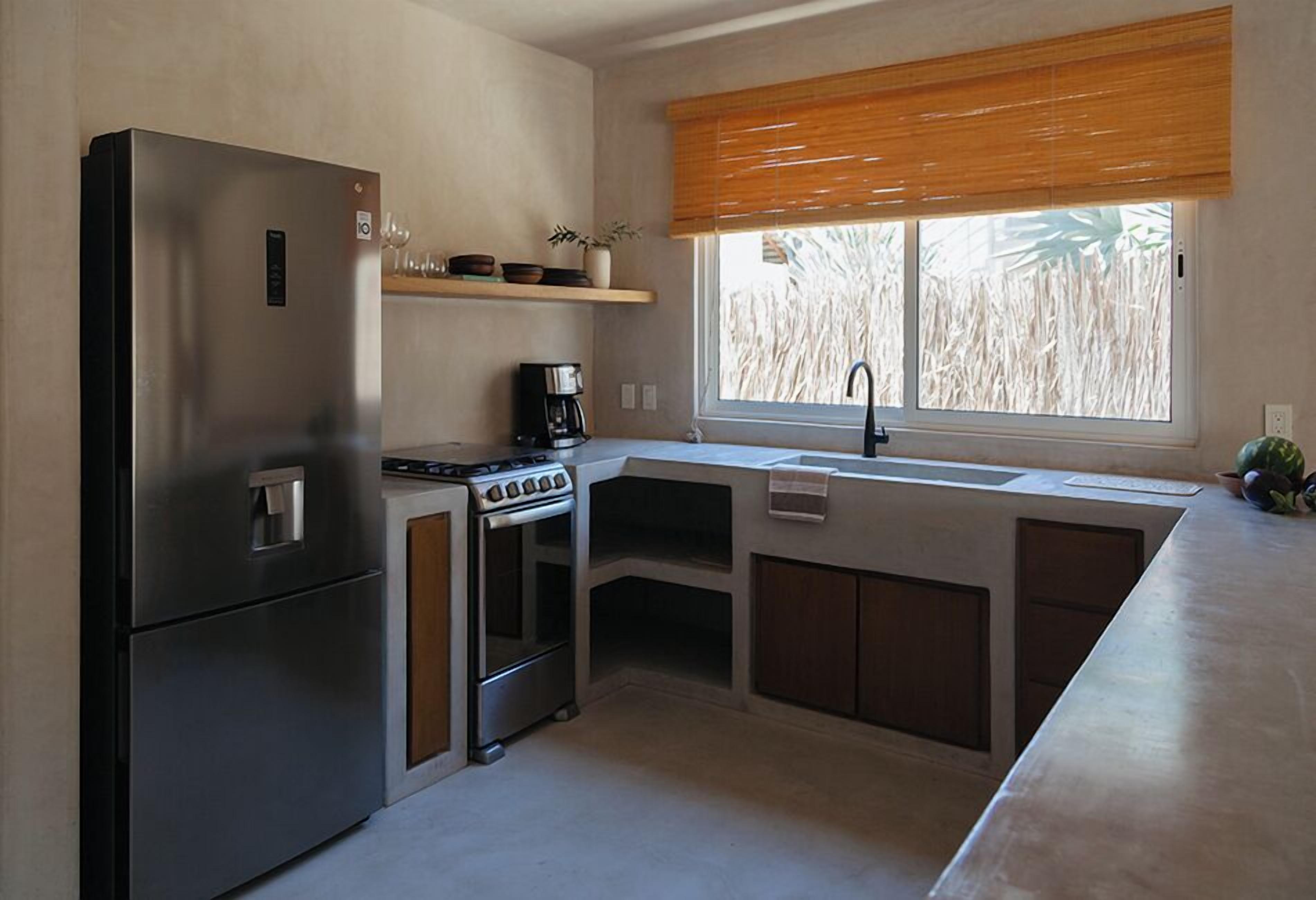 A compact kitchen with a refrigerator, stove, and sink.