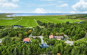 Ländliche Landschaft mit Häusern, umgeben von viel Grün und Feldern.