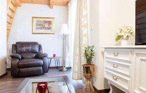 A living room with a leather sofa, a small round table with a red cup, a floor lamp, a potted plant, and a white dresser with gold handles. - Stunning home in Tuheljske Toplice with sauna (Tuheljske Toplice)