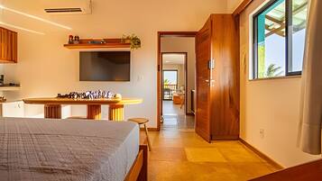 Ein modernes Hotelzimmer mit Bett, Schreibtisch, Fernseher und Blick ins Freie.