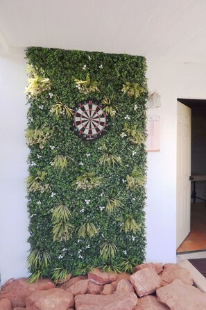 Eine Wand mit einem Dartspiel und einem fest montierten Thermostat.