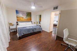 A bedroom with a bed, a desk, a chair, a ceiling fan, and a painting on the wall. - Walk to Old Town Pool + Bunkhouse | Sleeps 8 (Scottsdale)