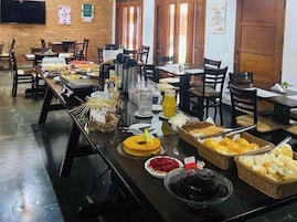 Disposição de buffet com diversos alimentos e bebidas.