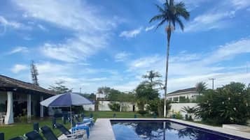 Una piscina al aire libre, sombrillas