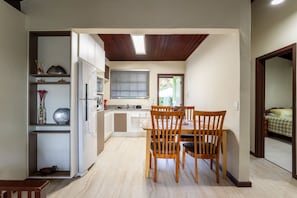 A compact kitchen with a dining area, built-in shelves, and a window.