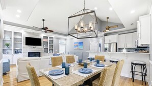 A modern kitchen with white cabinets, a built-in oven, and a dining area with a table set for six. - 4BR NMB Ocean Drive Cottage, quiet community and walk to everything you need! (North Myrtle Beach)