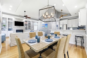 A modern kitchen with white cabinets, a built-in oven, and a dining area with a table set for six. - 4BR NMB Ocean Drive Cottage, quiet community and walk to everything you need! (North Myrtle Beach)