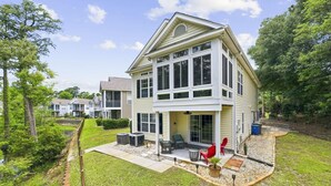 A two-story house with a covered patio, outdoor seating, and a small garden area. - 4BR NMB Ocean Drive Cottage, quiet community and walk to everything you need! (North Myrtle Beach)