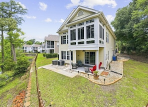 A two-story house with a covered patio, outdoor seating, and a small garden area. - 4BR NMB Ocean Drive Cottage, quiet community and walk to everything you need! (North Myrtle Beach)