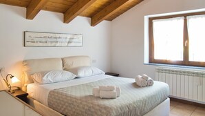 Une chambre à coucher avec un lit, une fenêtre, un radiateur et une lampe.