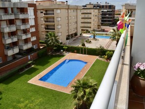 A residential building with a swimming pool, balconies, and surrounding greenery. - R166 Apartment 50m from the sea with two swimming pools (Calafell)