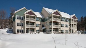 A multi-story hotel with balconies, large windows, and a snow-covered landscape. - Vermont Mountain Escape Near Skiing with Spacious 2BR Deluxe Retreat (Cambridge)