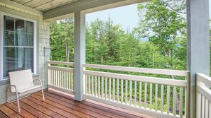A covered porch with a white railing, a bench, and a view of a forested area. - Vermont Mountain Escape Near Skiing with Spacious 2BR Deluxe Retreat (Cambridge)