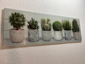 Una pantalla montada en la pared con diversas plantas en macetas.