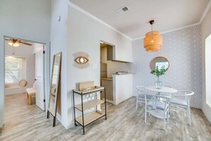 A modern kitchen with a dining area, a ceiling fan, and a decorative wall piece. - Modern Dallas Retreat (Dallas)