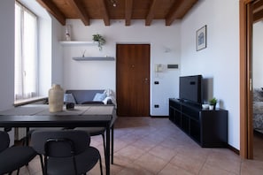 A modern living room with a dining table, chairs, a sofa, a TV, and a wooden ceiling. - A comfortable and bright 39 square meters apartment, perfect for three people, located on the first floor of a completely renovated 17th-century historic building (NO elevator).The property is located in Valeggio sul Mincio and enjoys an excellent locati (Valeggio sul Mincio)