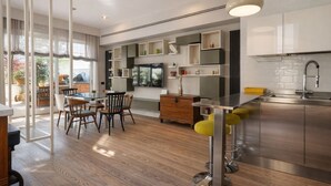 A modern kitchen with a dining area, built-in shelves, and a large window. - Elegantis Terrazze al Vaticano - Your Chic Retreat in Central Rome (Roma)