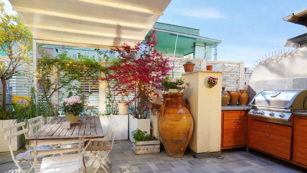 An outdoor patio with a wooden table and chairs, a large vase, a grill, and potted plants. - Elegantis Terrazze al Vaticano - Your Chic Retreat in Central Rome (Roma)