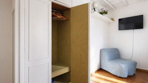 A room with a wardrobe, a television, and a blue chair. - Elegantis Pantheon Suite near Piazza Navona - Historic Centre (Roma)