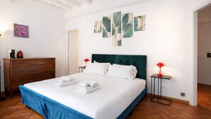 A hotel room with a large bed, a dresser, a red lamp, and artwork on the wall. - Elegantis Pantheon Suite near Piazza Navona - Historic Centre (Roma)