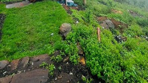 A small, single-story building with a balcony, surrounded by lush greenery and fog. - Adventure trails (Kodaikanal)