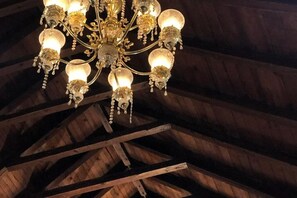 Un candelabro con múltiples luces colgando de una estructura de techo de madera.
