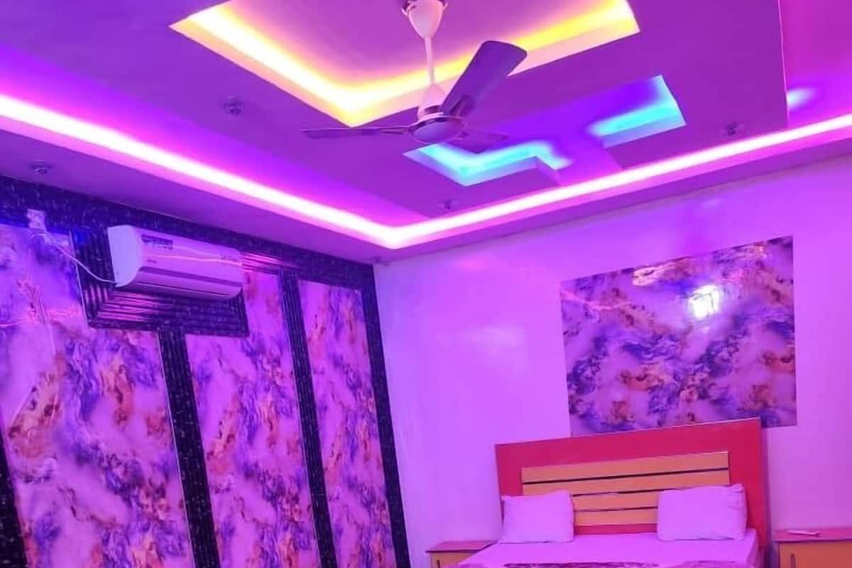 Un dormitorio con una cama, dos sofás, un ventilador de techo y un suelo con estampado de mármol.