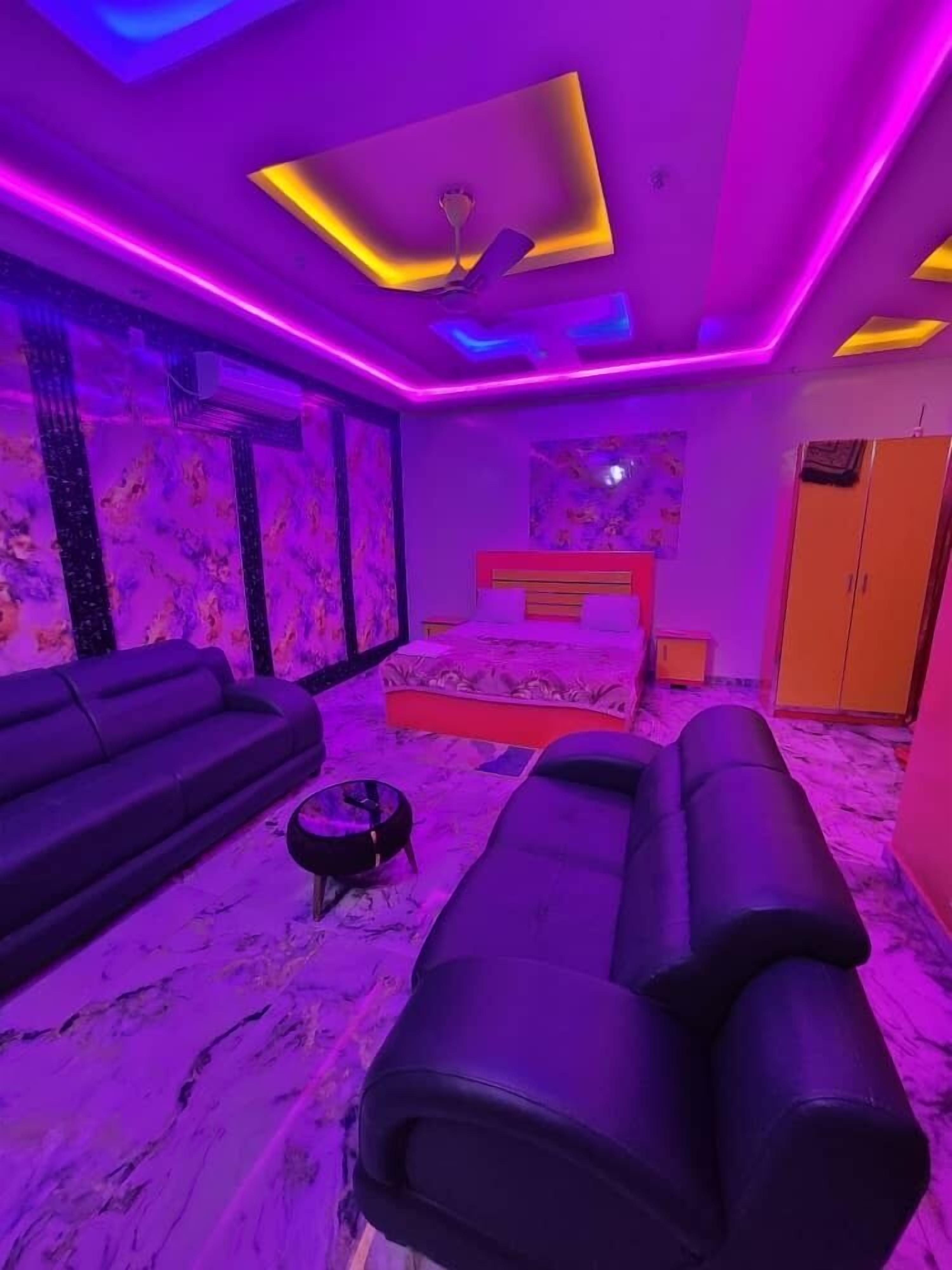 Een kamer met een bed, een massagetafel, een bank en een plafondventilator.