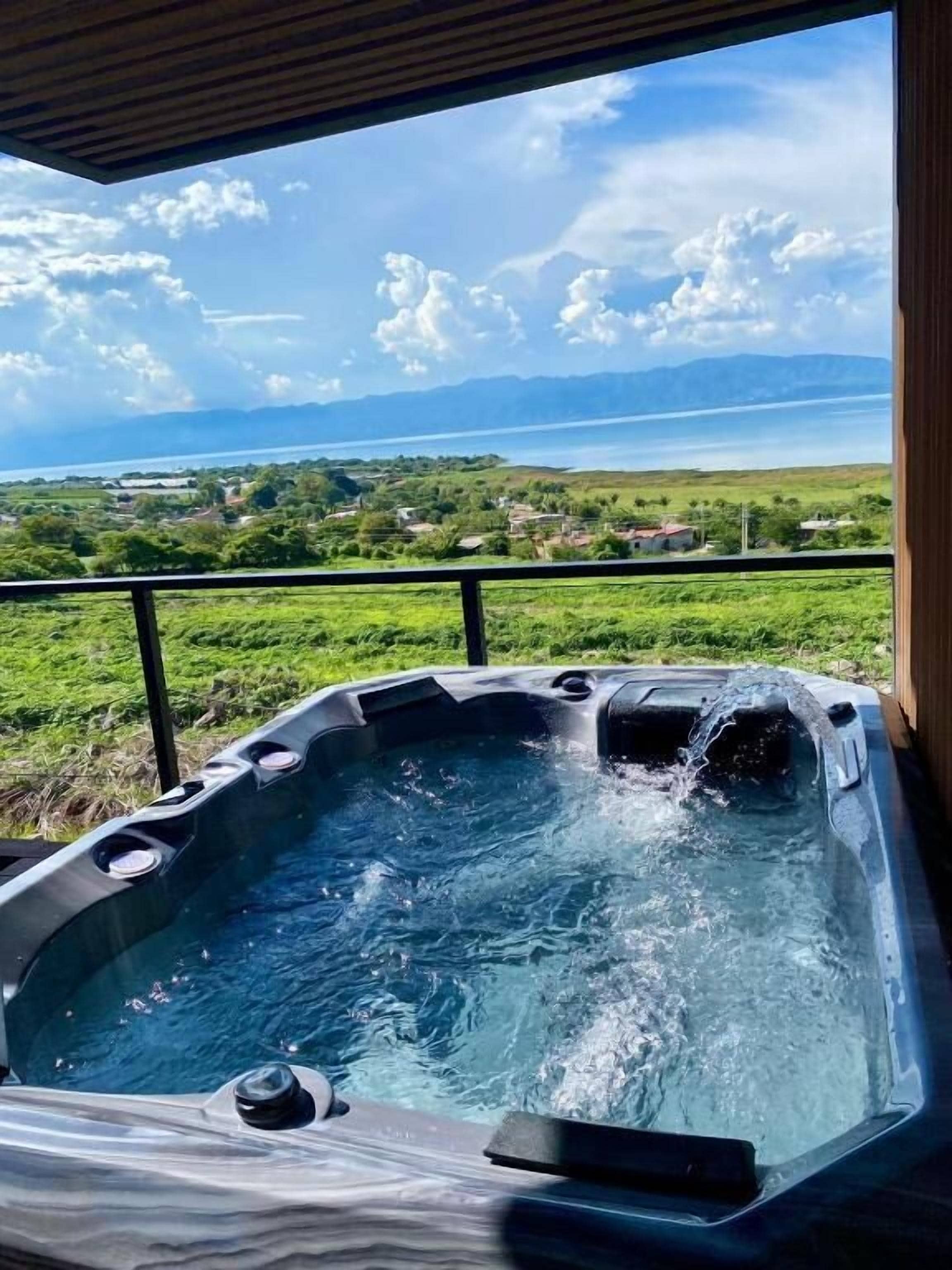Un jacuzzi con vistas a un lago y montañas.