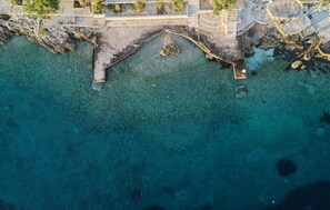 An aerial view of a coastal area with a stone bridge leading to a rocky shore. - Amazing apartment in Okrug Donji with WiFi (Okrug Donji)